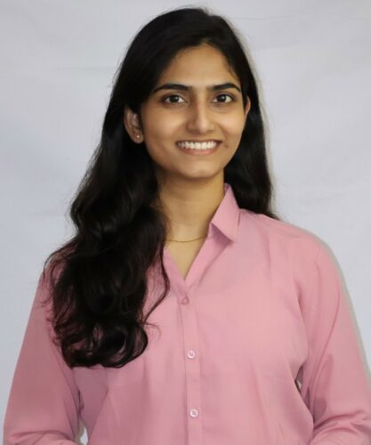 A portrait of a woman in a pink button-down.